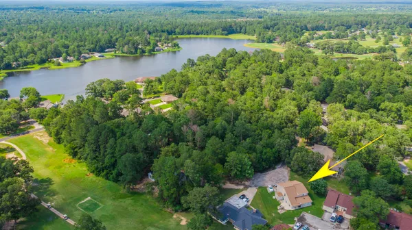 an aerial view of residential houses with outdoor space and lake view