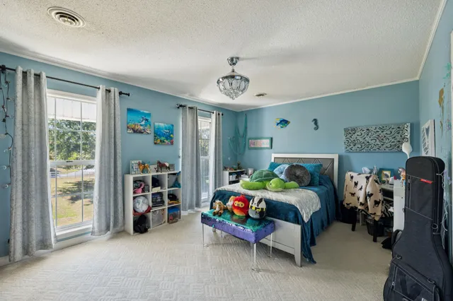 a view of a house with large trees and sitting area