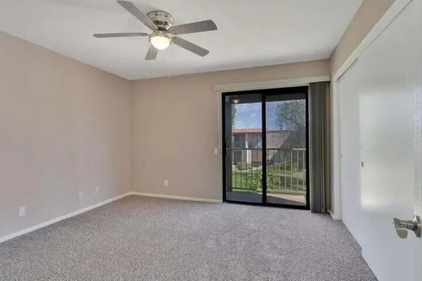 a view of a room with windows and ceiling fan