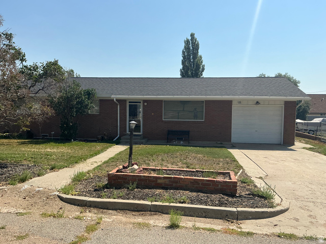98 Main Street Manila, UT 84046 - Photo 1 of 36 Brick exterior with an attached garage, featuring a concrete driveway and front walkway