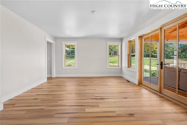 a view of an empty room with glass door and balcony