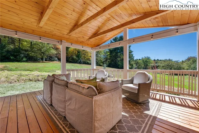 a view of a patio with couches chairs and wooden floor