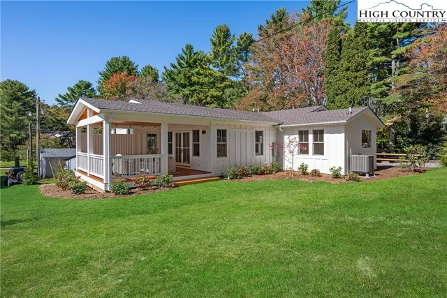 a view of a house with a yard and sitting area