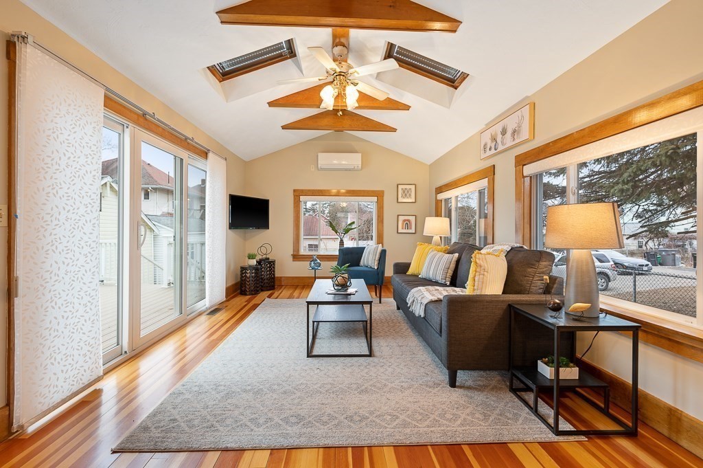 17 George Street Framingham, MA 01702 - Photo 15 of 38 a living room with furniture a chandelier and a floor to ceiling window