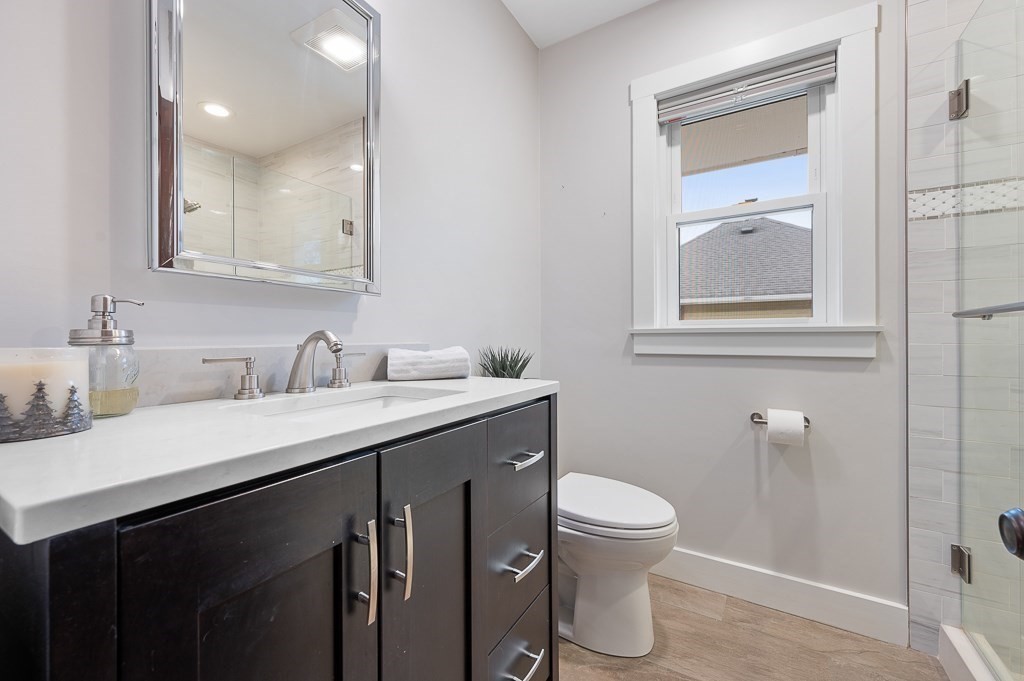 17 George Street Framingham, MA 01702 - Photo 20 of 38 a bathroom with a granite countertop sink a toilet and a mirror