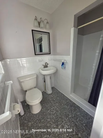 a bathroom with a toilet a sink and mirror