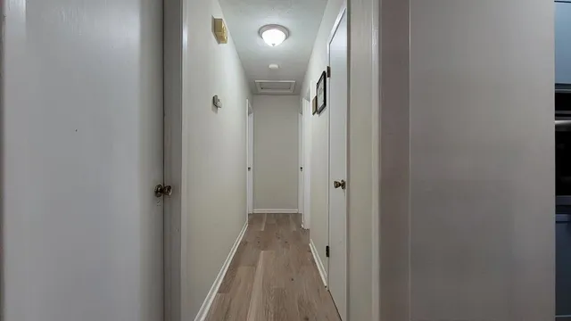 a view of a hallway with wooden floor