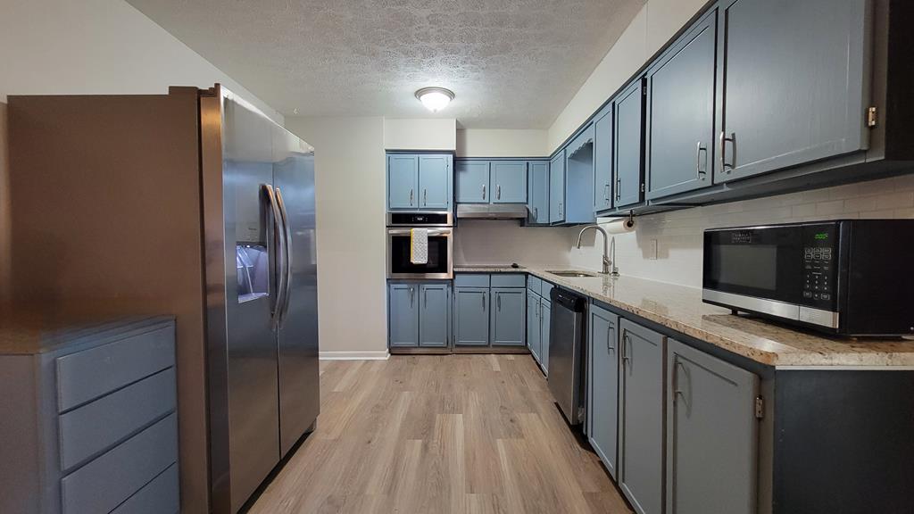 4804 Bruning Street Columbus, GA 31907 - Photo 4 of 14 a kitchen with stainless steel appliances wooden cabinets a refrigerator and a stove top oven