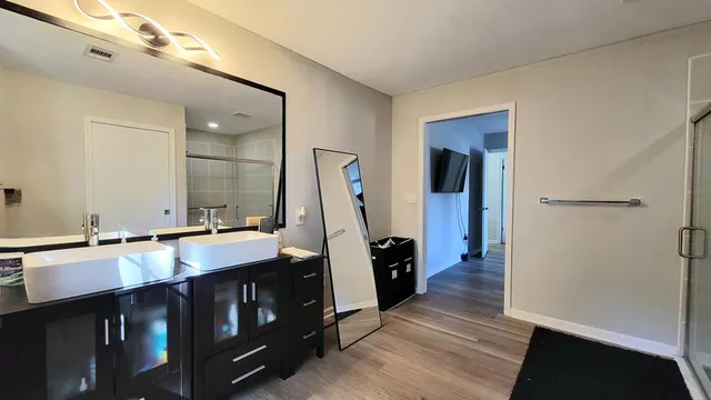 a bathroom with double vanity and a mirror