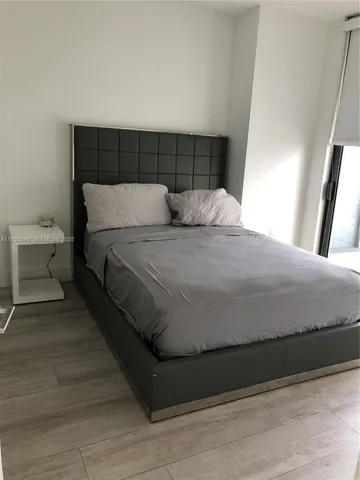 a large bed sitting in a bedroom next to a window