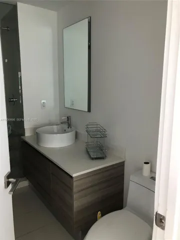 a bathroom with a granite countertop sink toilet and mirror