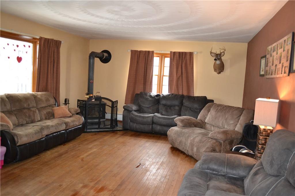 The living room has lots of natural light, original hardwood floors, and a woodburner.