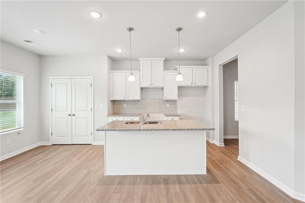 3014 Viewpark Circle Conyers, GA 30013 - Photo 12 of 44 a view of a kitchen with kitchen island a sink dishwasher a stove and a refrigerator with wooden floor