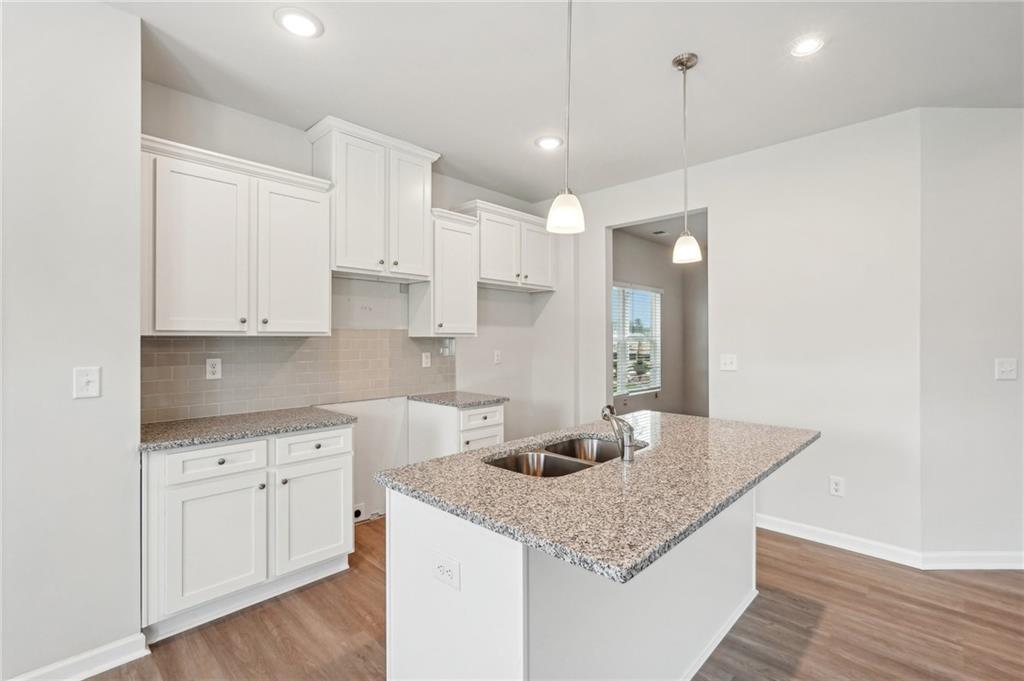 3014 Viewpark Circle Conyers, GA 30013 - Photo 14 of 44 a kitchen with a sink dishwasher and white cabinets with wooden floor