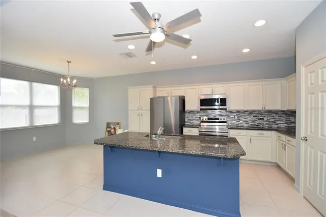 a kitchen with stainless steel appliances granite countertop a sink refrigerator and microwave