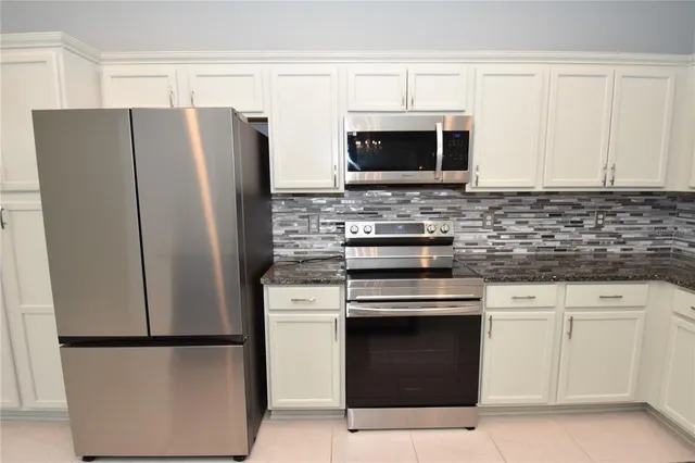 a kitchen with stainless steel appliances a refrigerator stove and microwave