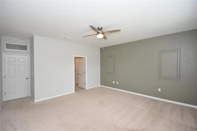 an empty room with closet and a ceiling fan