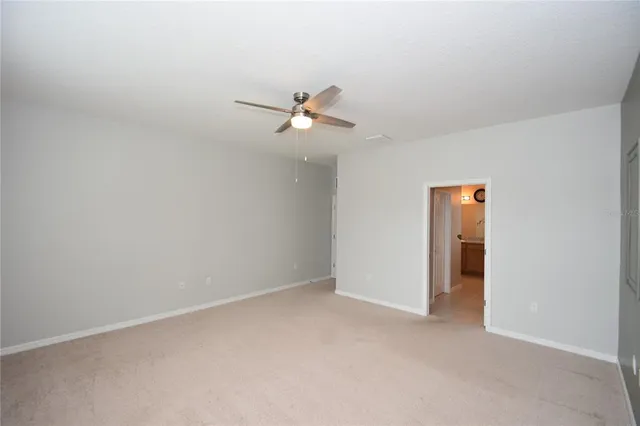 an empty room with closet and a ceiling fan