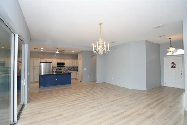 a view of a room with a cabinet and chandelier