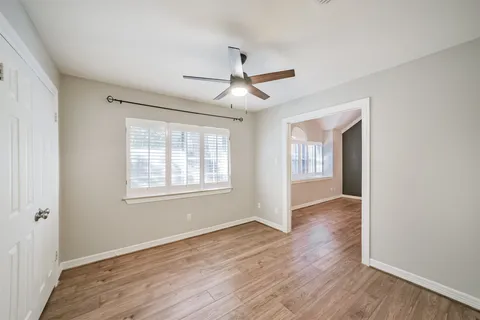 a view of a workspace with wooden floor and a window