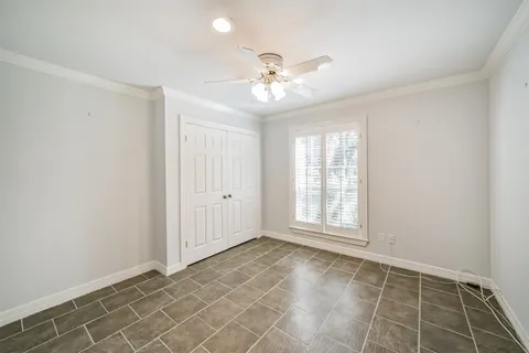 an empty room with windows and fan