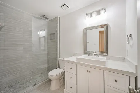 a bathroom with a sink a toilet and shower