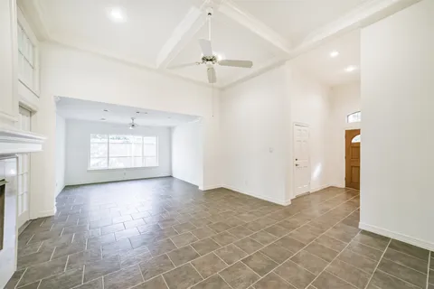 an empty room with windows and fireplace