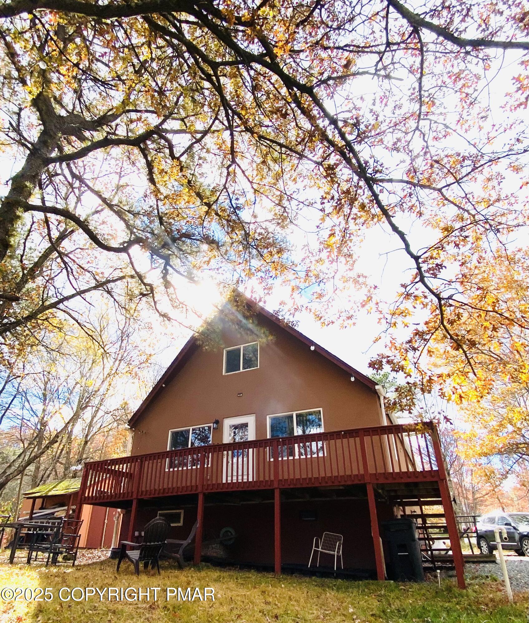 a view of a house with a yard and wooden deck