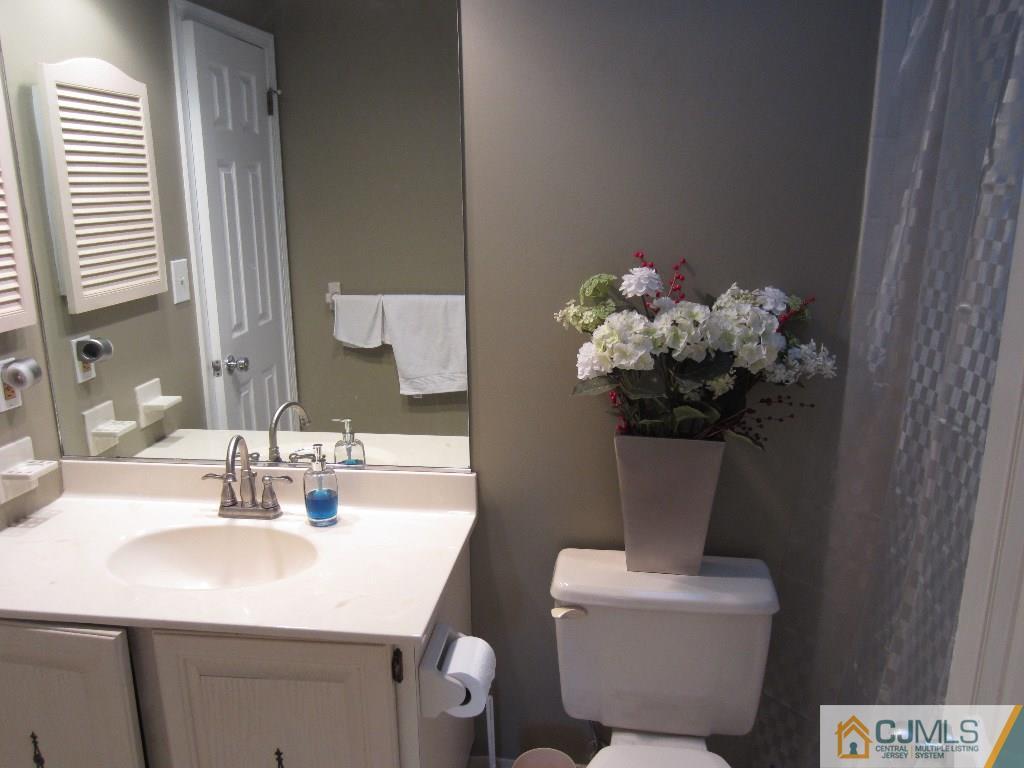 2201 Timber Oaks Road Edison, NJ 08820 - Photo 8 of 12 a bathroom with a sink mirror and toilet