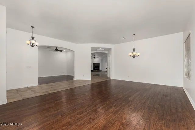 an empty room with wooden floor and entrance