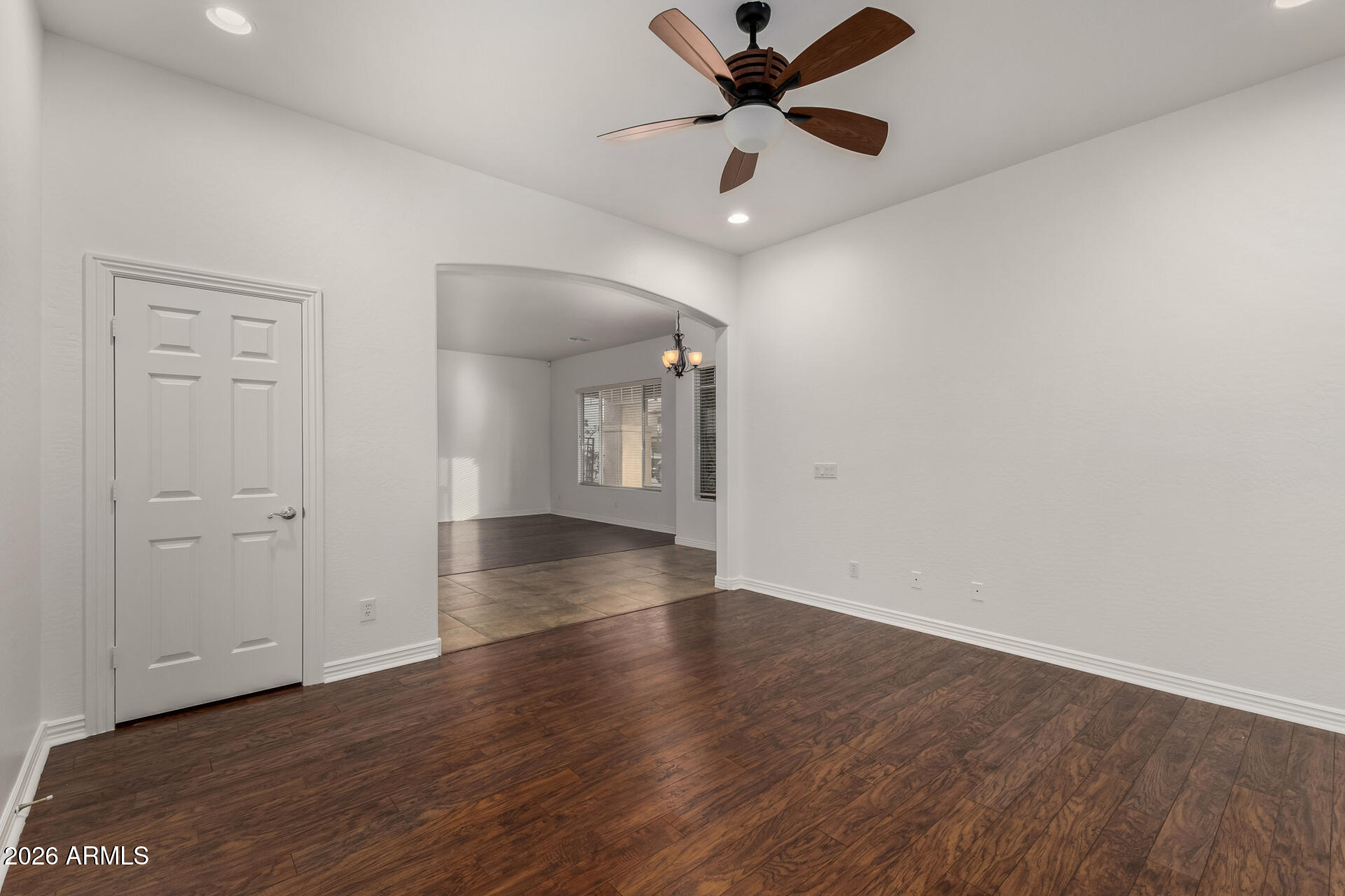 9638 West Bajada Road Peoria, AZ 85383 - Photo 4 of 26 an empty room with wooden floor a ceiling fan and windows