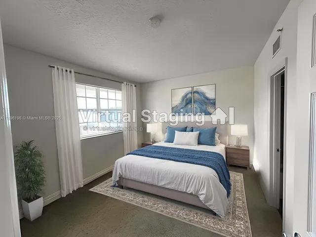 a bedroom with a bed table and a window