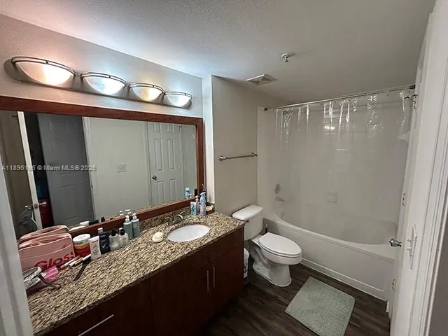 a bathroom with a granite countertop sink toilet and shower