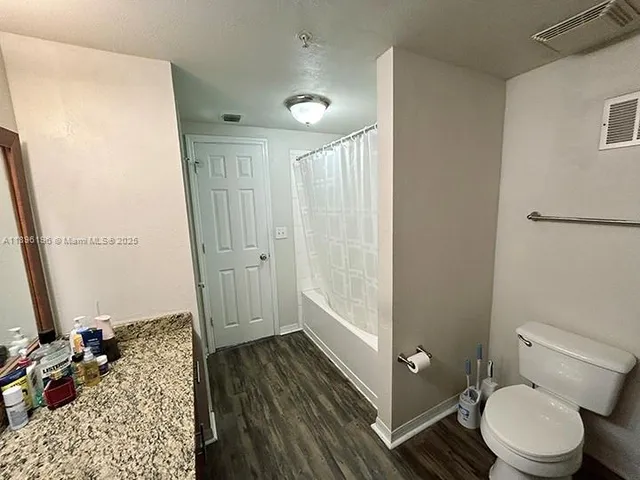 a bathroom with a granite countertop sink toilet and shower