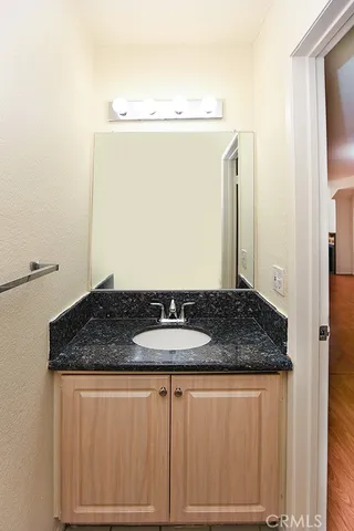 a bathroom with a granite countertop sink and a mirror