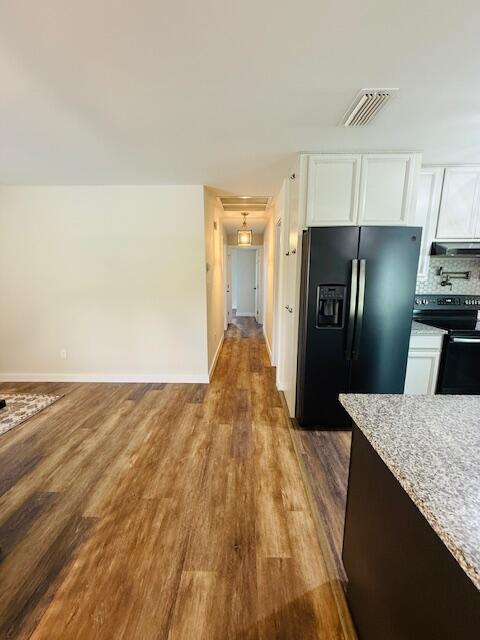 541 South Brocksmith Road Fort Pierce, FL 34945 - Photo 9 of 36 a view of a kitchen with refrigerator and wooden floor