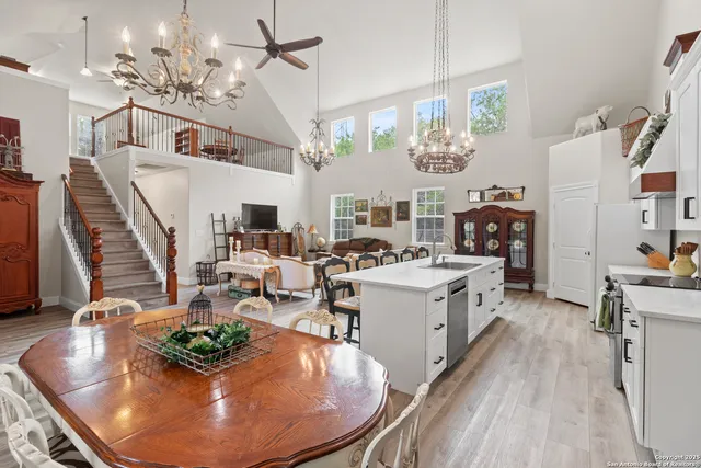 a kitchen with a sink dishwasher a stove and a dining table with wooden floor