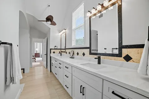 a spacious bathroom with a tub sink and mirror