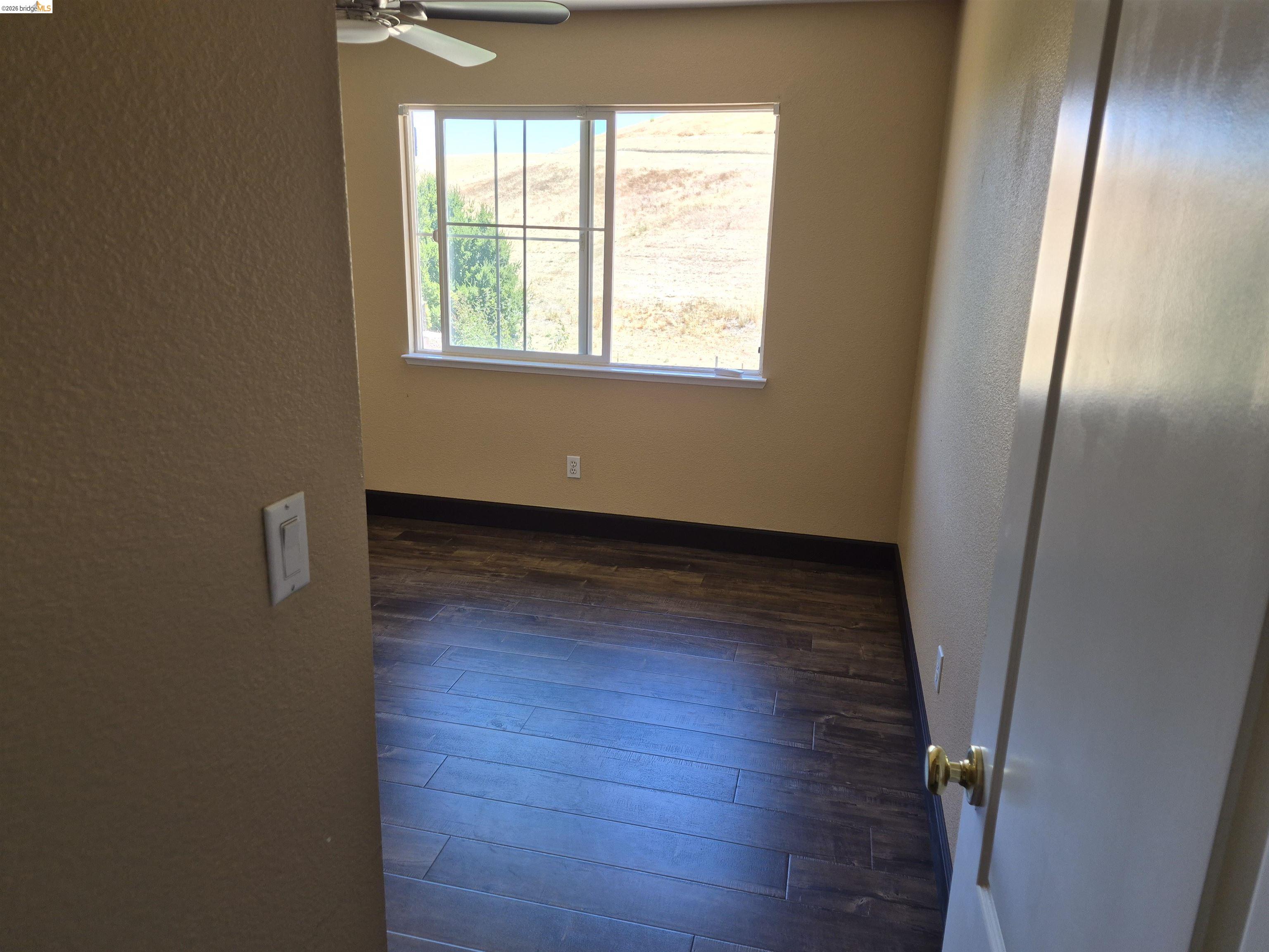 149 Oakpoint Court Bay Point, CA 94565 - Photo 14 of 22 Room featuring wood-finish flooring, a window with horizontal grids, and a ceiling fan
