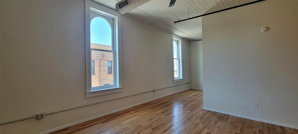 201 East Chambers Street, Unit 203 Cleburne, TX 76031 - Photo 7 of 8 a view of empty room with wooden floor and fan