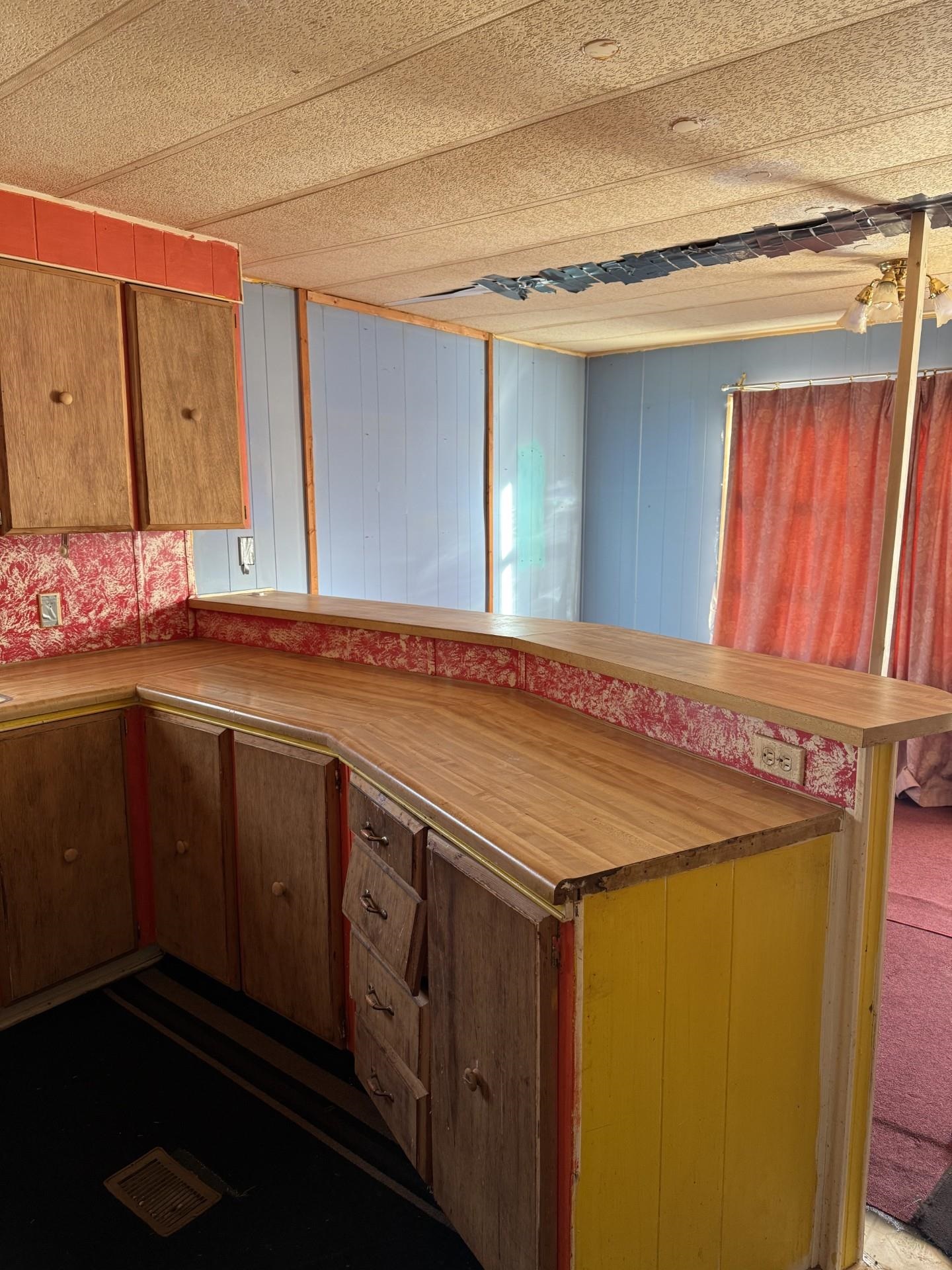 1625 Cary Street Ashland, WI 54806 - Photo 2 of 8 Kitchen featuring light countertops, brown cabinetry, and wooden walls