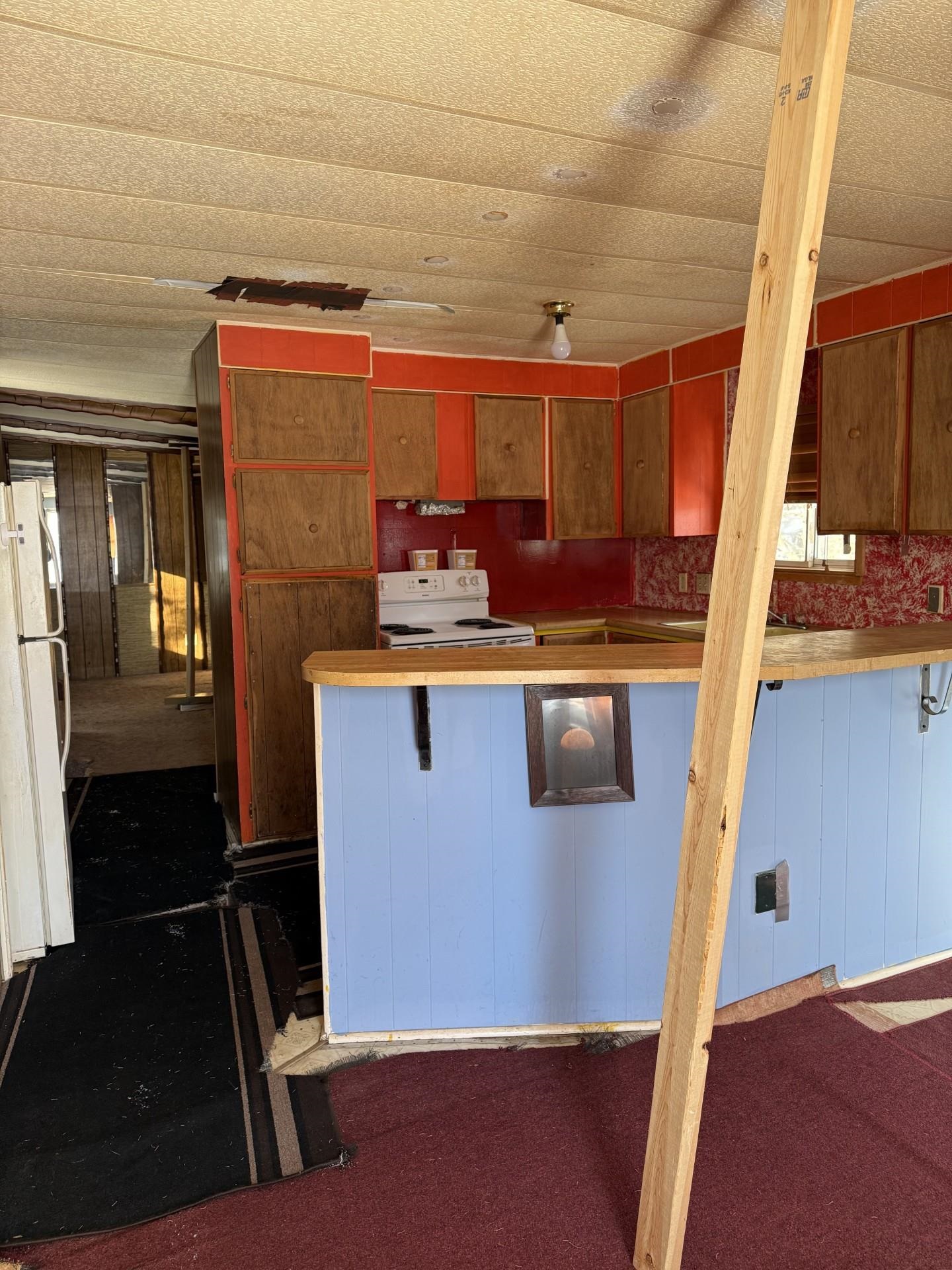 1625 Cary Street Ashland, WI 54806 - Photo 3 of 8 Kitchen featuring white appliances, brown cabinetry, light countertops, and a peninsula