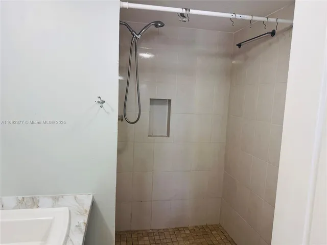 a bathroom with a shower and a sink