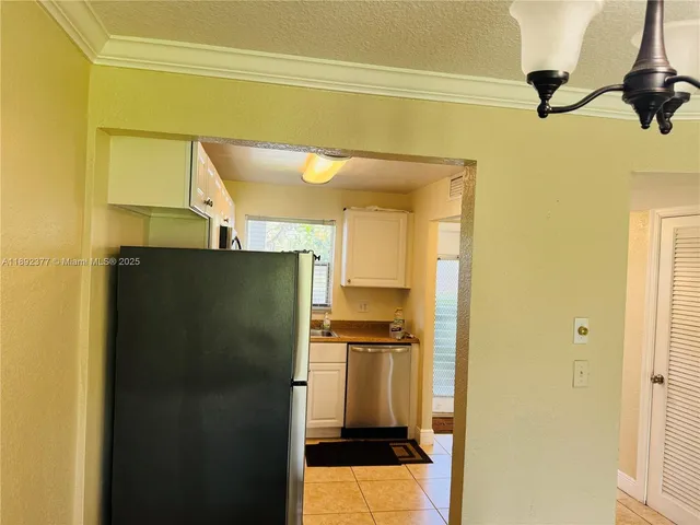 a metallic refrigerator freezer sitting in a kitchen
