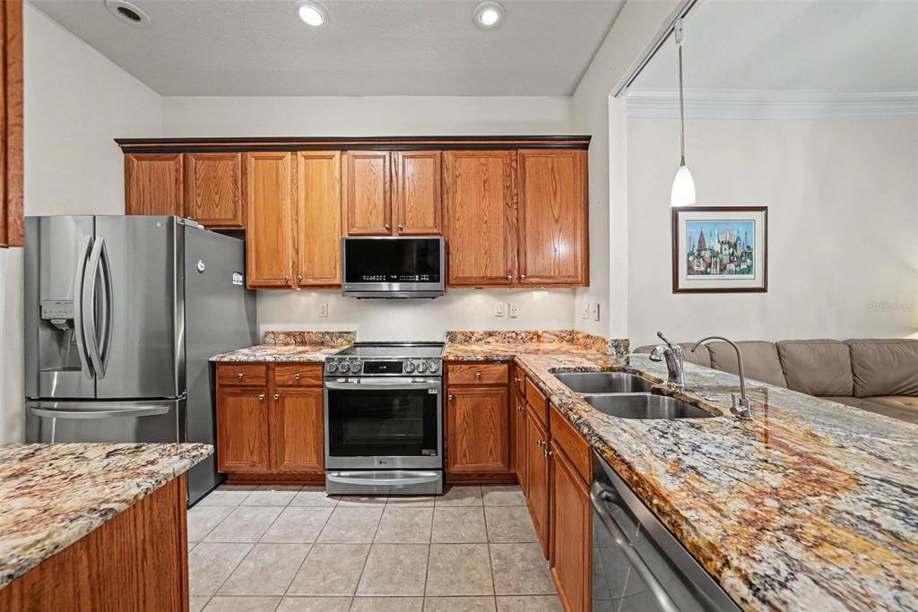 7411 Wimpole Drive New Port Richey, FL 34655 - Photo 3 of 21 a kitchen with stainless steel appliances granite countertop a stove top oven a sink dishwasher a refrigerator and a microwave