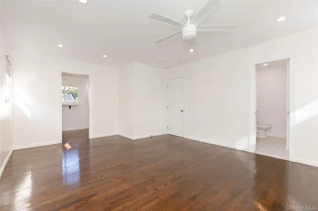 a view of a kitchen with wooden floor and a kitchen space with a sink