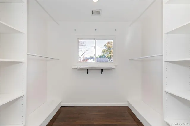 an empty room with wooden floor and ceiling fan