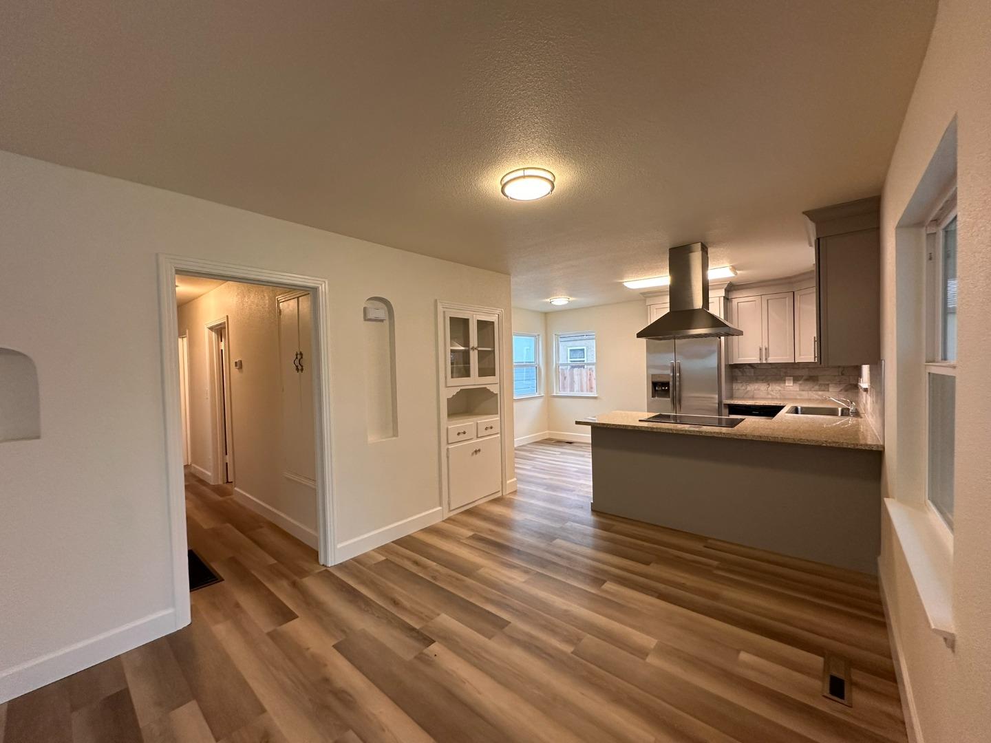 1220 Church Street Lodi, CA 95240 - Photo 4 of 31 a large living room with kitchen view and wooden floor