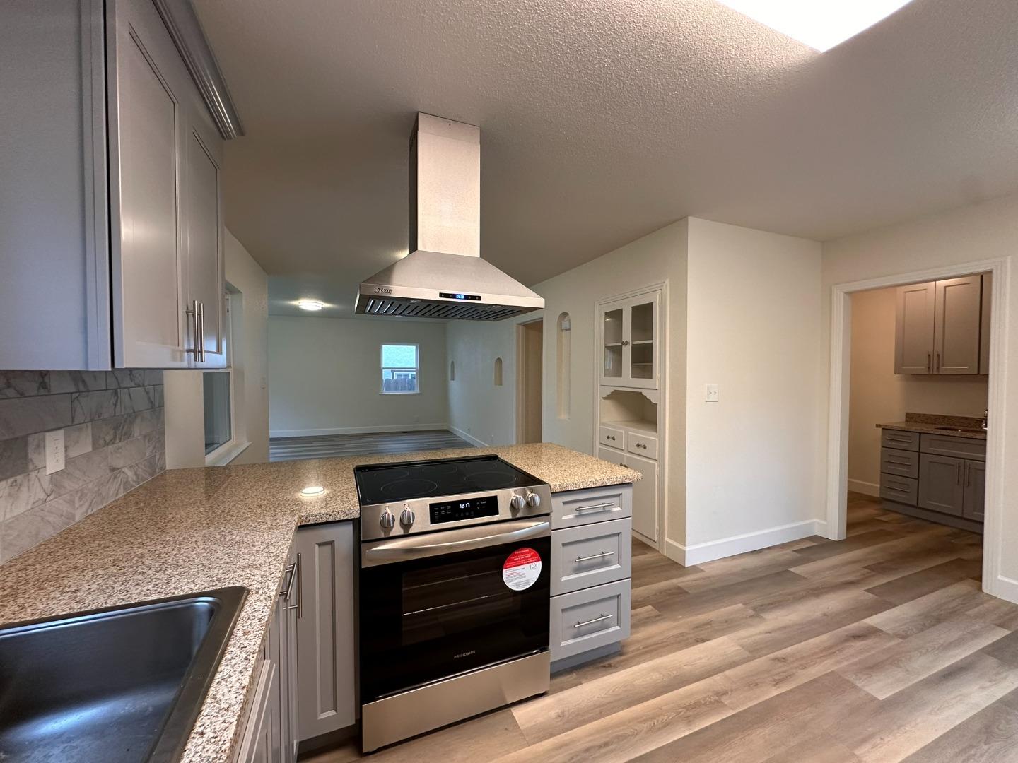 1220 Church Street Lodi, CA 95240 - Photo 8 of 31 a kitchen with granite countertop a stove and a refrigerator