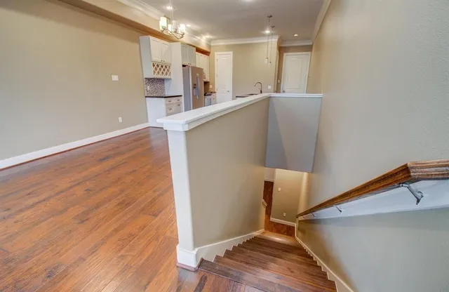 a view of a kitchen with wooden floor and staircase